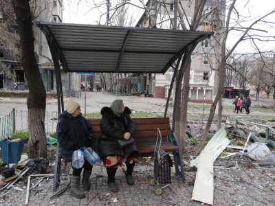 People sit outdoors in Mariupol, Ukraine, on April 14, 2022.