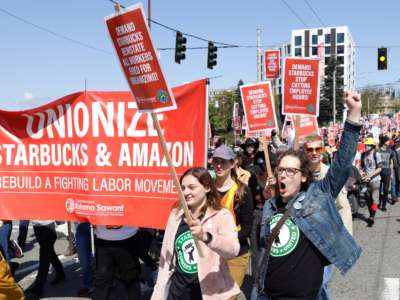 People march in the middle of East Pine Street during the "Fight Starbucks' Union Busting" rally and march in Seattle, Washington, on April 23, 2022.