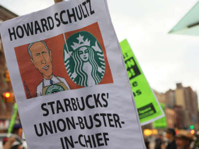 People hold signs while protesting in front of Starbucks on April 14, 2022, in New York City.