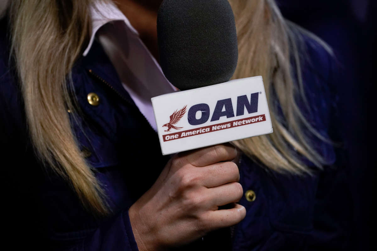 A reporter with One America News Network works at a campaign rally with President Donald Trump at Newport News/Williamsburg International Airport on September 25, 2020, in Newport News, Virginia.