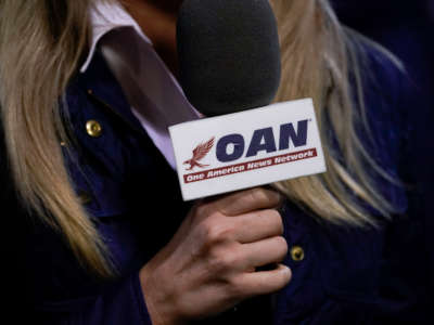 A reporter with One America News Network works at a campaign rally with President Donald Trump at Newport News/Williamsburg International Airport on September 25, 2020, in Newport News, Virginia.