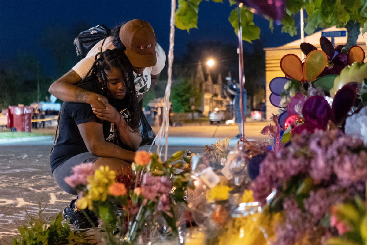 Two people embrace eachother at a streetside memorial for the victims of the racist Buffalo, New York, shooting