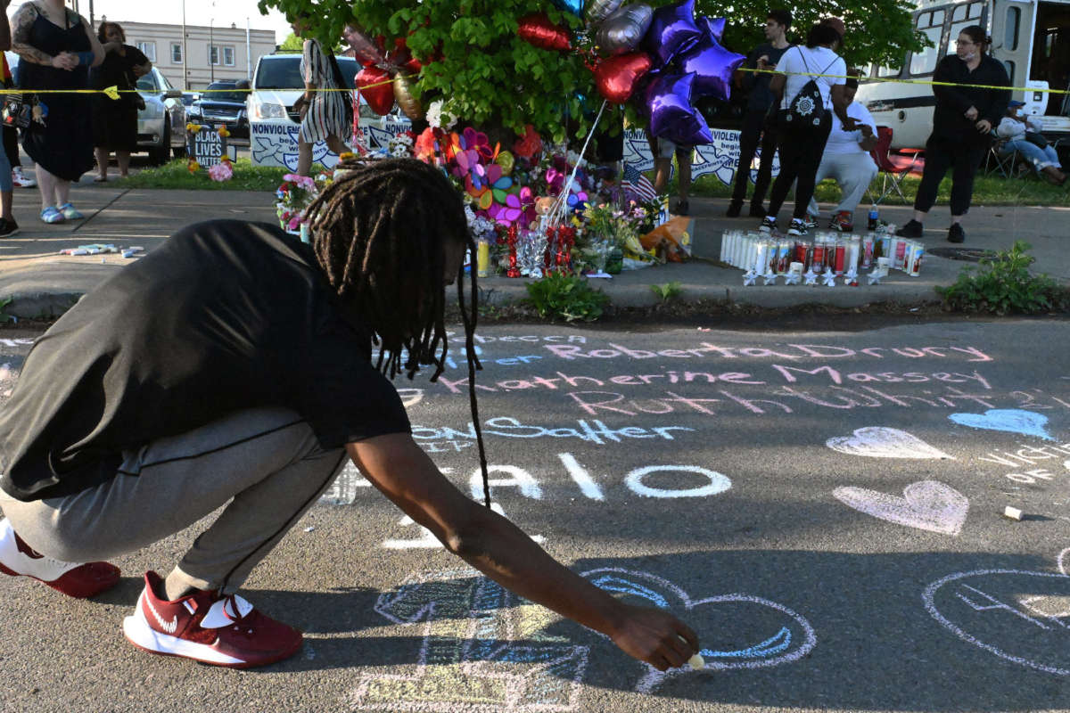 People leave messages at a makeshift memorial near a Tops grocery store in Buffalo, New York, on May 15, 2022, the day after a gunman killed 10 people.