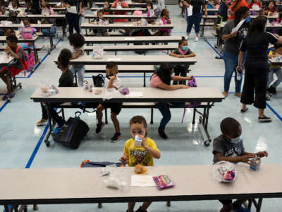 Students eat breakfast as they arrive for the first day of school at Matt Kelly Elementary Community School in Las Vegas, Nevada, on August 9, 2021.