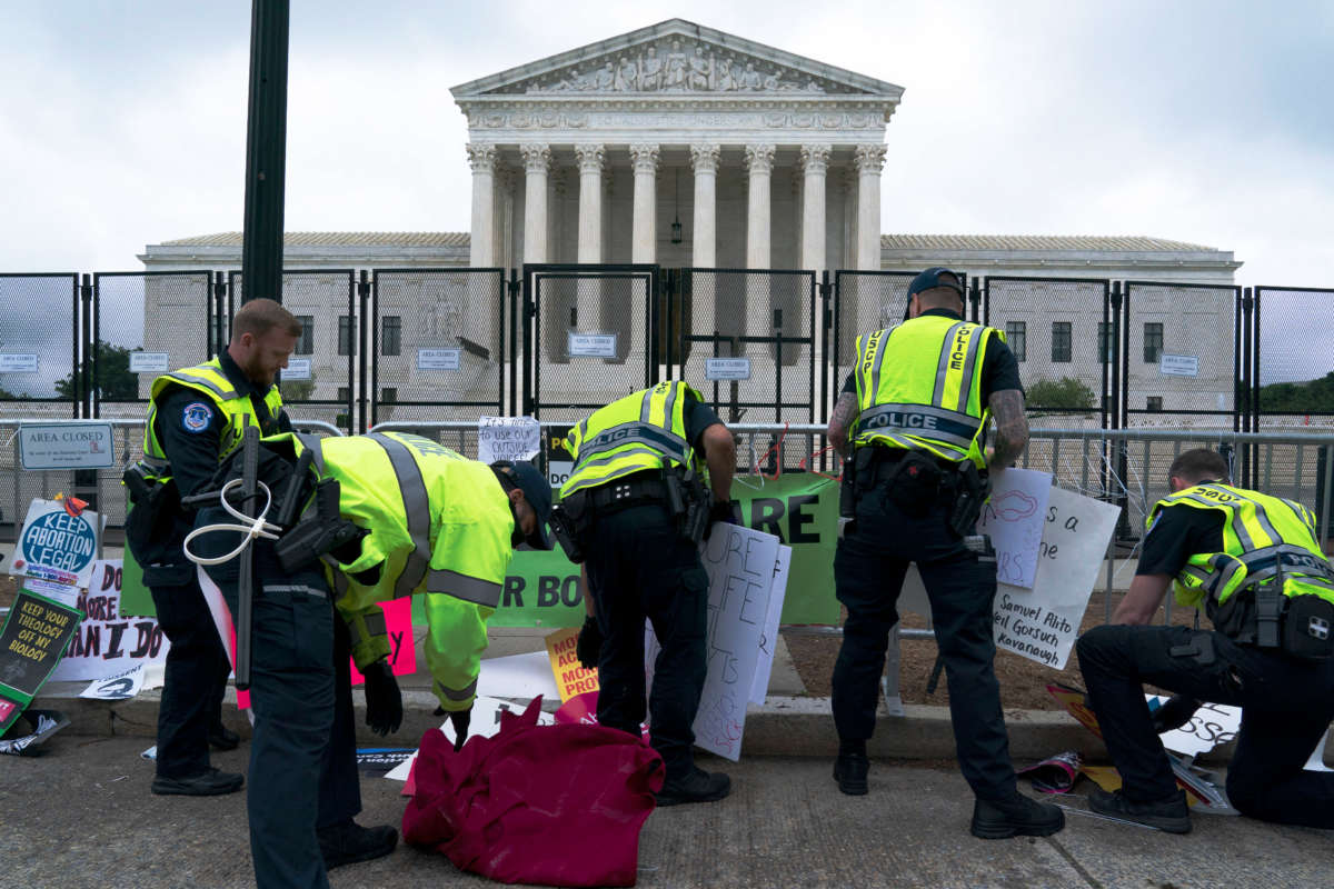 U.S. Capitol police remove banners and signs left at a fence by abortion rights demonstrators outside of the U.S. Supreme Court in Washington, D.C., on May 14, 2022.