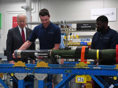 President Joe Biden watches employees as he tours the Lockheed Martins Pike County Operations facility in Troy, Alabama, on May 3, 2022.