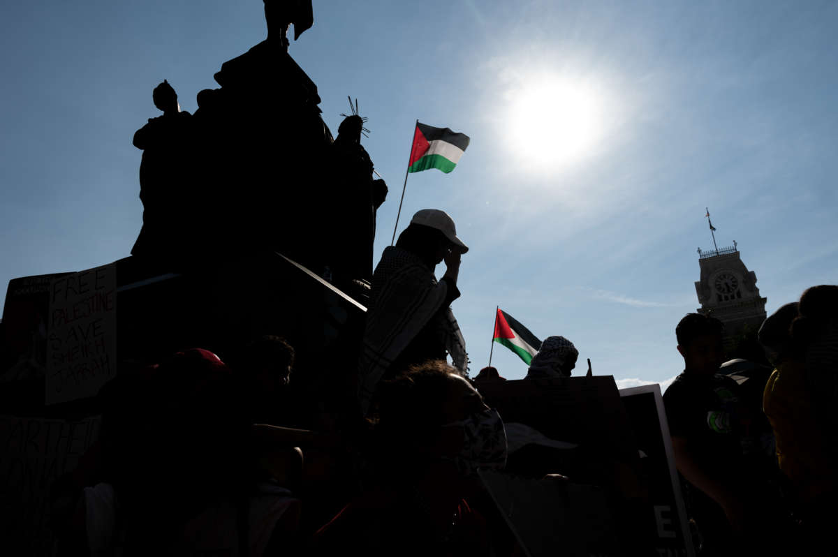 People listen to speakers and hold signs during a pro-Palestine protest on the steps of City Hall on May 23, 2021, in Louisville, Kentucky.