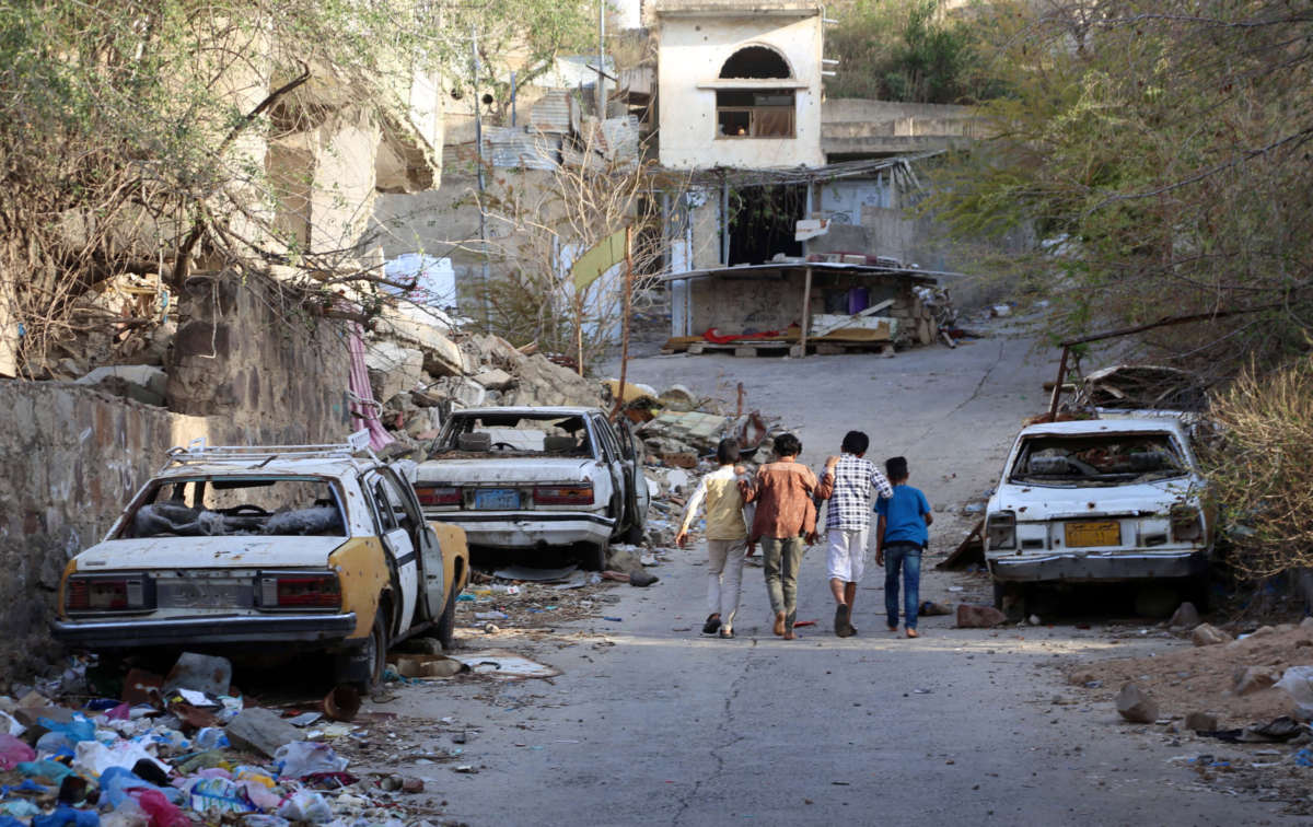 Children walk near damaged cars in the city of Taez, Yemen, on May 17, 2022.