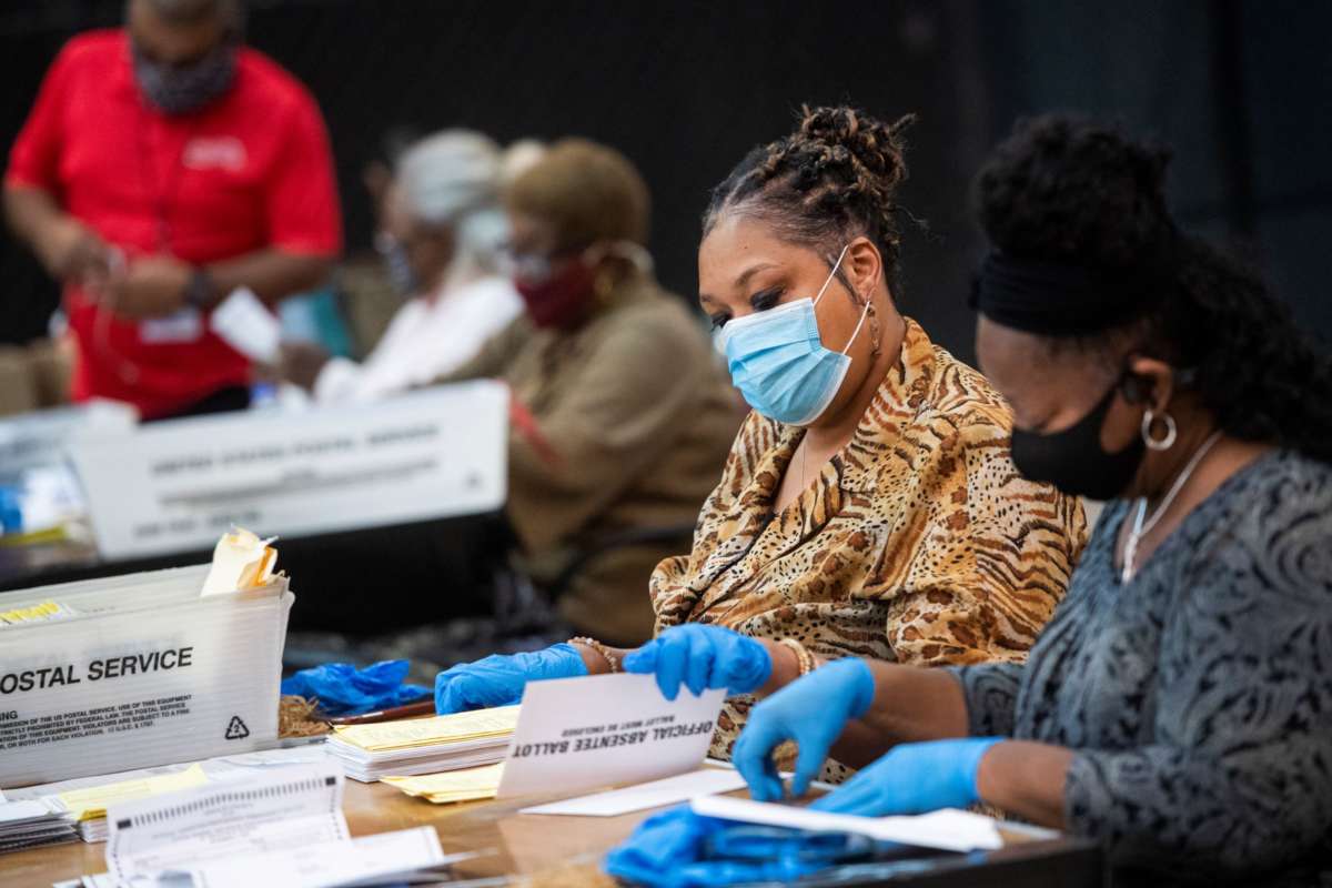 Election workers open ballots in preparation for scanning at the Dekalb County Voter Registration and Elections Office in Decatur, Georgia, on Monday, November 2, 2020.