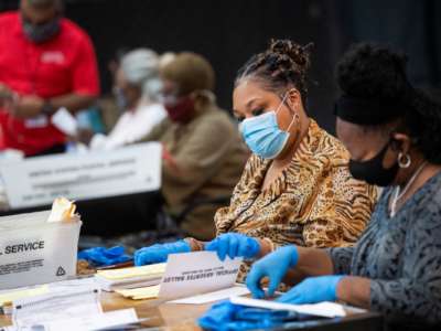 Election workers open ballots in preparation for scanning at the Dekalb County Voter Registration and Elections Office in Decatur, Georgia, on Monday, November 2, 2020.