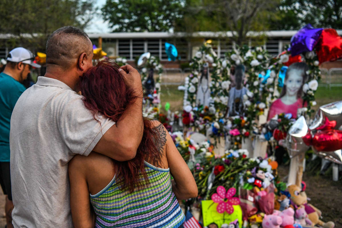 People pay tribute and mourn at a makeshift memorial for the victims of the Robb Elementary School shooting in Uvalde, Texas, on May 31, 2022.