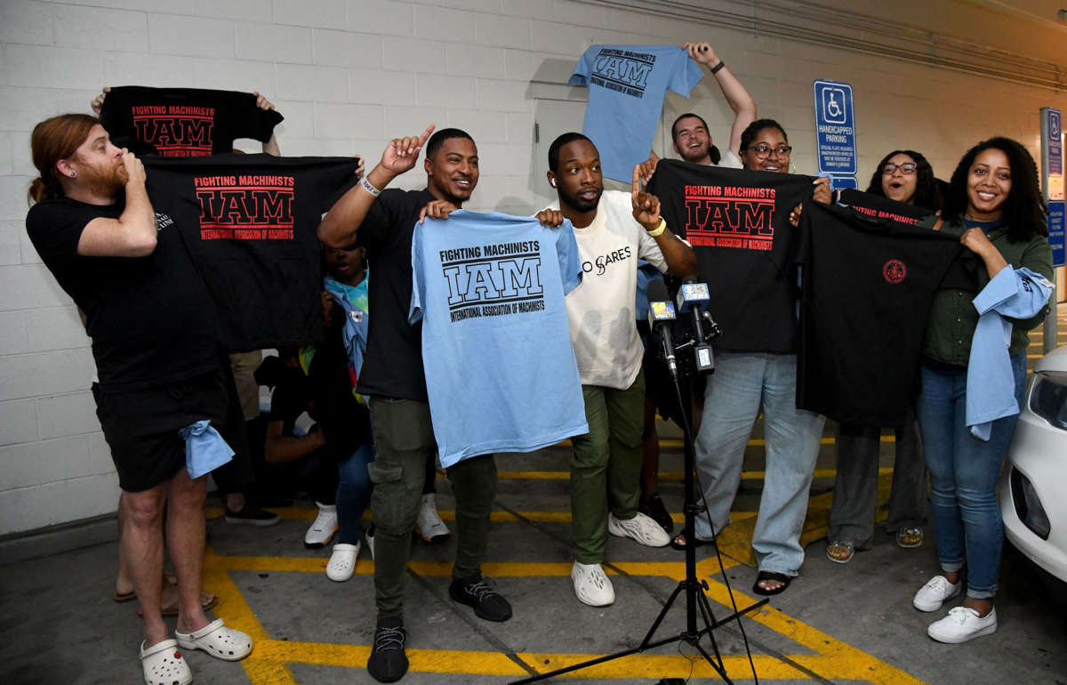 Workers at the Towson Town Center Apple hold their new union T-shirts on June 18, 2022, after their store employees decided to join the International Association of Machinists Union.