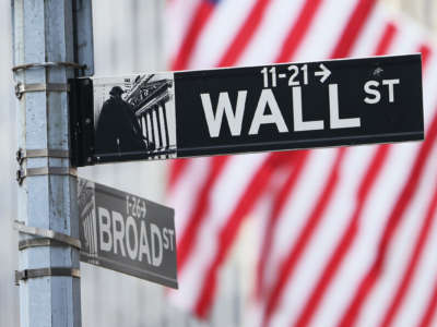 Wall Street sign is seen before American flags