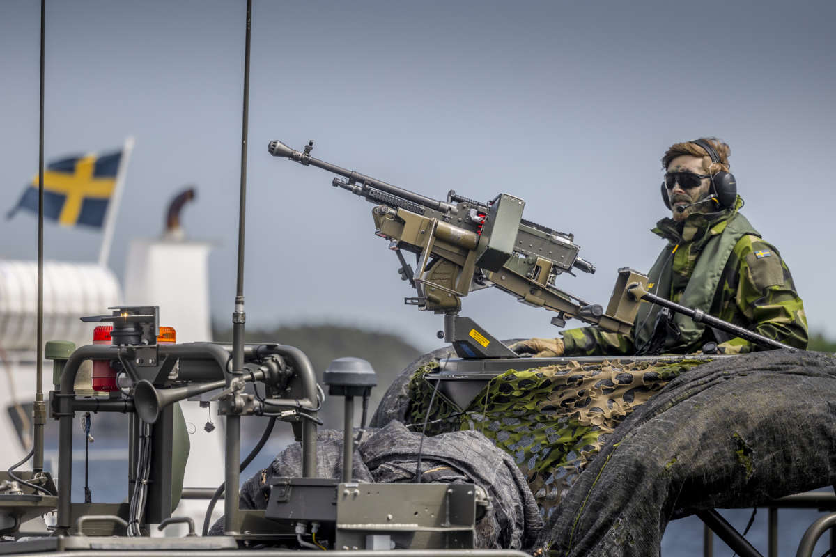 A Swedish soldier sits on a military boat with a machine gun during the Baltic Operations NATO military drills on June 11, 2022, in the Stockholm archipelago on Sweden's eastern coastline.