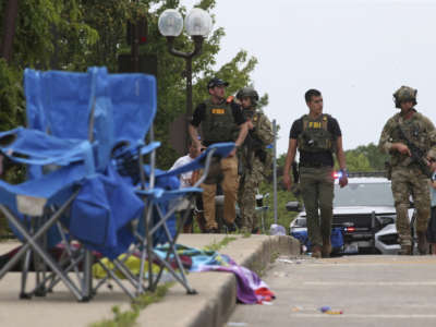 Law enforcement officers from multiple jurisdictions investigate the area in Highland Park, Illinois, on July 4, 2022, after a shooter fired on the Chicago suburb's Fourth of July parade.
