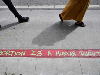 Graffiti written on a red zone which reads "Abortion Is A Human Right" is seen as abortion rights activists march in protest from the Federal Courthouse to City Hall in Los Angeles, California, on July 6, 2022.