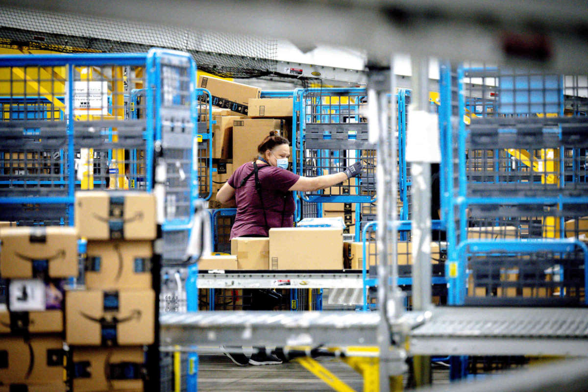 A worker sorts out parcels in the outbound dock at Amazon fulfillment center in Eastvale, California on Tuesday, Aug. 31, 2021.