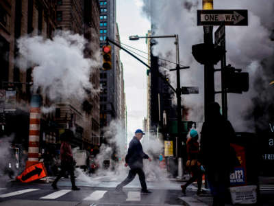 A man walks across an incredibly smoggy New York intersection