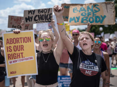 McKayla Wolff, left, and Karen Wolff join hands as they rally for abortion rights in St. Paul, Minnosota, on July 17, 2022.