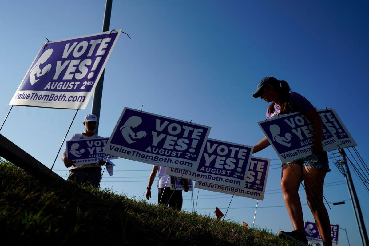 Supporters of the Vote Yes to a Constitutional Amendment on Abortion remove signs along 135th Street on August 1, 2022, in Olathe, Kansas.