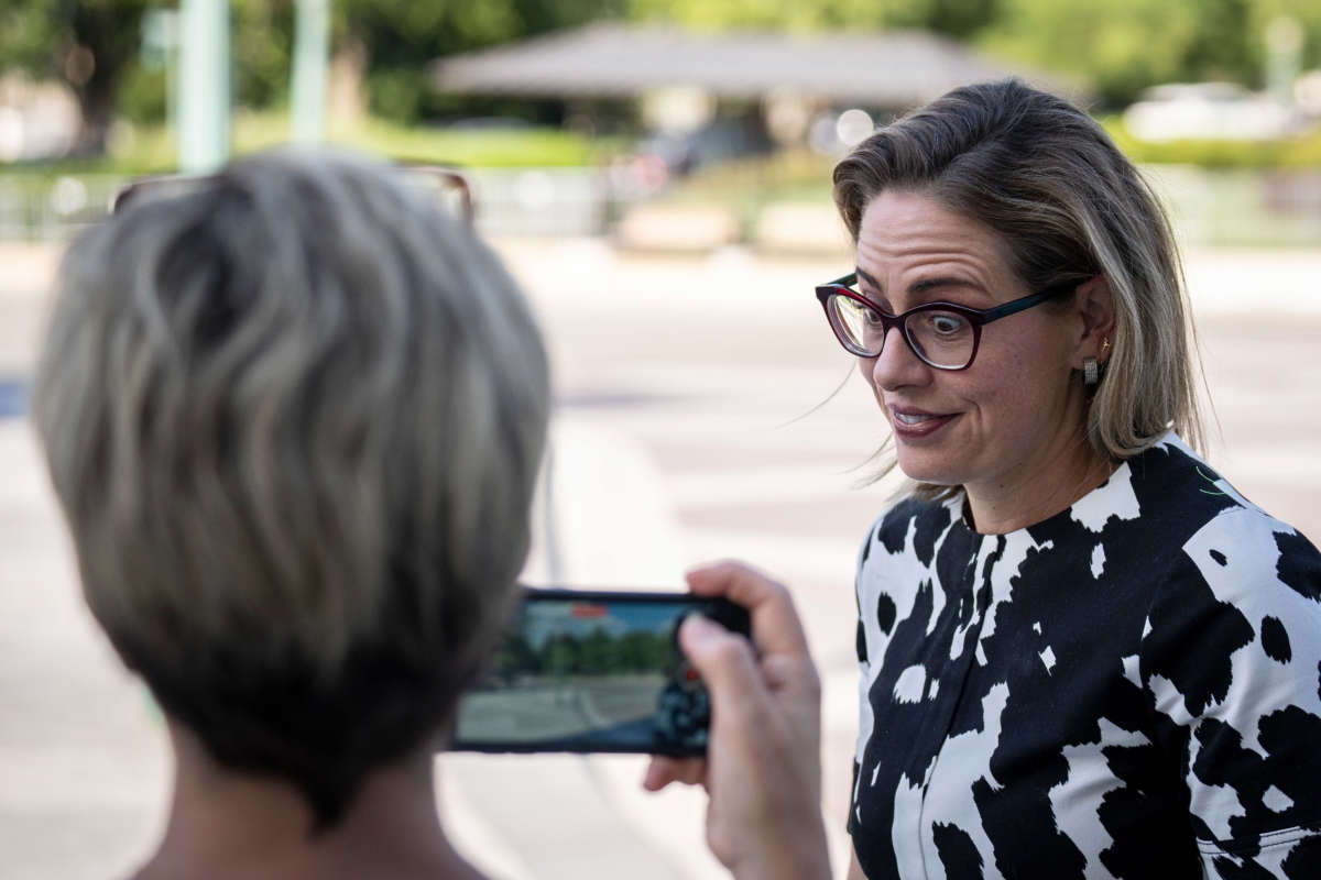 Sen. Kyrsten Sinema reacts to a journalist's question about whether she opposes closing the carried interest loophole that currently is part of the Democrats' $740 billion reconciliation bill, as she arrives at the U.S. Capitol for a vote on August 3, 2022, in Washington, D.C.