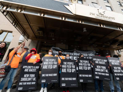 New York City restaurant workers rally outside Dine Brands shareholder meeting with signs reading 'the people who feed you are fed up' and 'Applebee's & Ihop are racist. New York shouldn't be. One Fair Wage Now!''