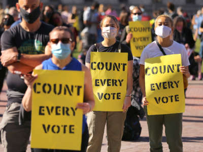 People hold signs reading 'count every vote' during a worker's rally in Copley Square in Boston just before Joe Biden was declared the President-Elect in Boston on November 7, 2020.