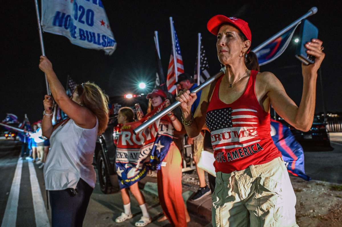 Trump supporters gather with their flags in the cover of darkness