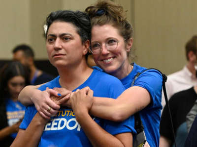 Iman Alsaden, chief medical officer for Planned Parenthood Great Plains, and Kelsey Rhodes of Kansas City hug as they and Kansans for Constitutional Freedom supporters celebrate a victory at the polls on August 2, 2022, at the Overland Park Convention Center.