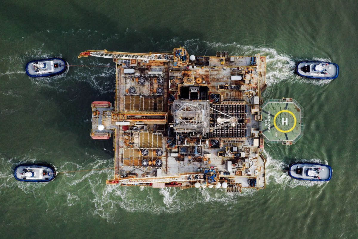 In this aerial image from a drone, tug boats tow the semi-submersible drilling platform Noble Danny Adkins through the Aransas Channel into the Gulf of Mexico on December 12, 2020, in Port Aransas, Texas.