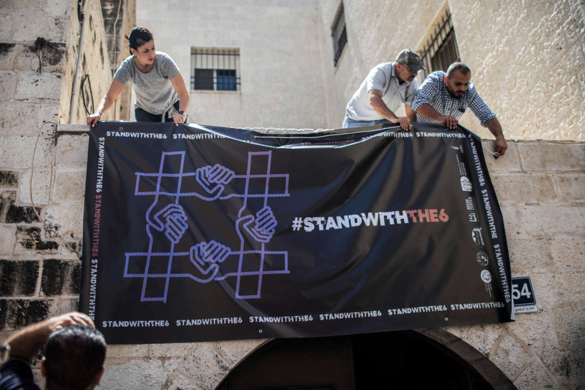Activists hang a poster at the entrance to al-Haq Human Rights Organization, after it was raided and shut down by Israeli Military forces, on August 18, 2022, in Ramallah, Palestine.