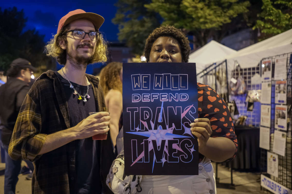Two attendees of the Glenwood Avenue Arts Festival in Chicago's Rogers Park neighborhood join a direct action in defense of trans lives on August 20, 2022. 