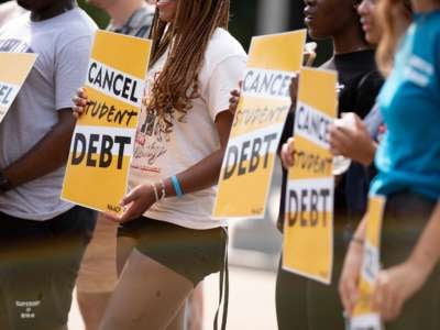 Activists hold cancel student debt signs as they gather to rally in front of the White House in Washington, D.C., on August 25, 2022.