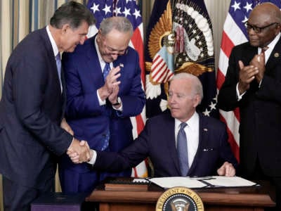 President Joe Biden shakes hands with Sen. Joe Manchin after signing the Inflation Reduction Act alongside Senate Majority Leader Charles Schumer and House Majority Whip James Clyburn in the State Dining Room of the White House, on August 16, 2022, in Washington, D.C.