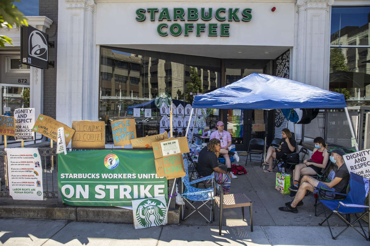 Starbucks workers and community members sit in a tent outside of Starbucks, where they demonstrated in front of the store 24/7 for two months.
