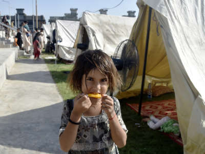 A flood-affected girl eats at a relief shelter in northwest Pakistan's Charsadda