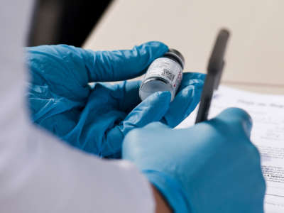 A nurse writes down information from a vial of Moderna COVID-19 vaccine at a mobile vaccine clinic setup in Reading, Pennsylvania, on April 19, 2021.