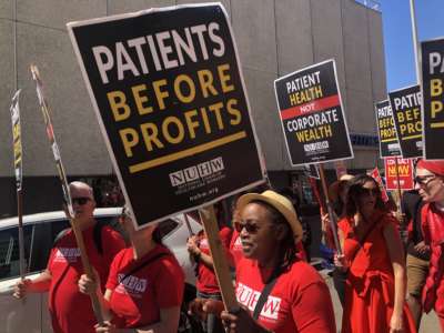 Striking mental health therapists march through downtown Oakland, California, on August 19, 2022, for a rally outside Kaiser Permanente’s corporate headquarters.