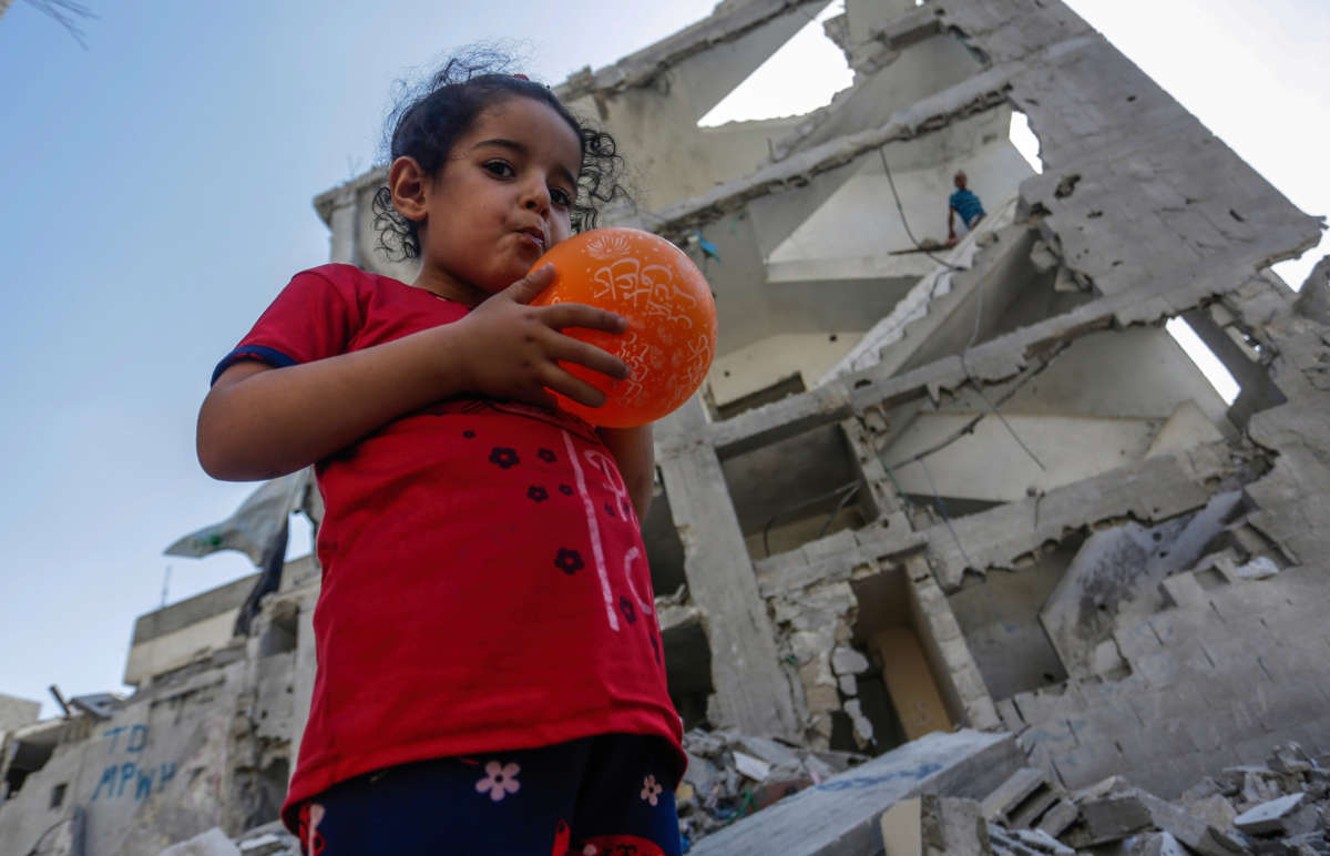 A Palestinian girl stands on the ruins of their destroyed house in the city of Rafah in the southern Gaza Strip on August 16, 2022.