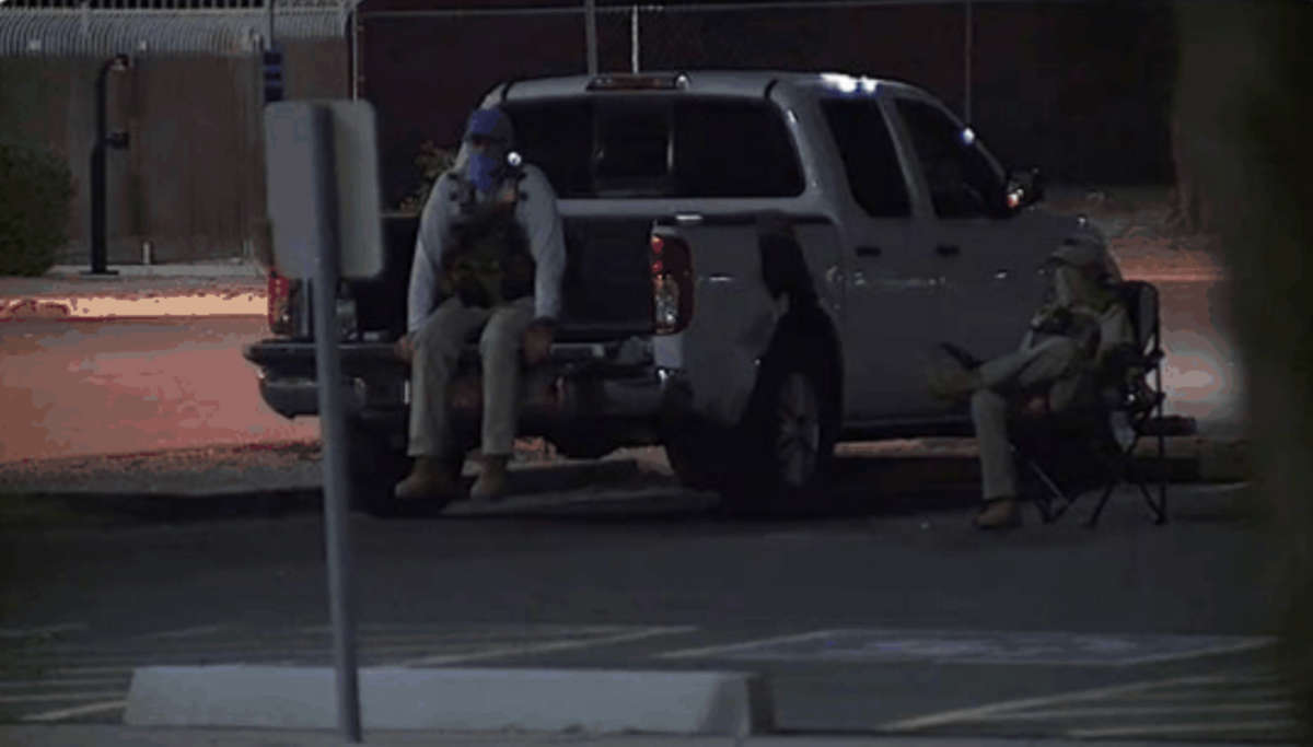 Armed vigilantes dressed in tactical gear watch a drop box site in this photograph disseminated by the Maricopa County Elections Department.