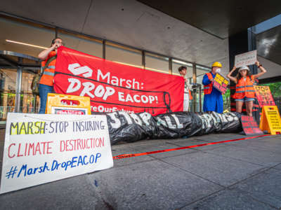 Activists rally outside the headquarters of insurance company Marsh McLennan in New York City, urging CEO Dan Glaser to cut ties with the East African Crude Oil Pipeline (EACOP) on July 1, 2022.