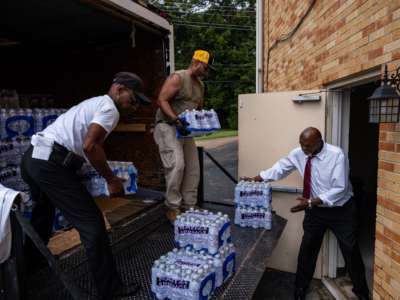 Members of Progressive Morningstar Baptist Church move cases of bottled water in Jackson, Mississippi, on September 4, 2022.