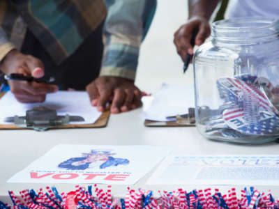View of hands of people registering to vote