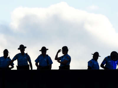 Police stand guard on a bridge as protestors block the road on the fourth day of protests following Rayshard Brooks's shooting death by police, on June 16, 2020, in Atlanta, Georgia.