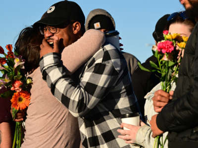 Jezeravon Swisher, center, gets comforted by friends at a makeshift memorial near Club Q on November 20, 2022, in Colorado Springs, Colorado.