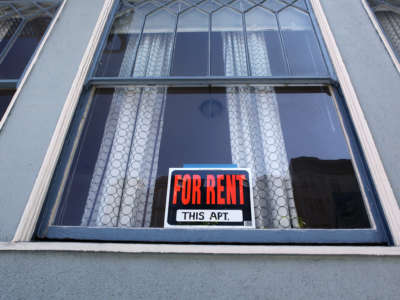 the exterior of a building with "for rent" sign on the front door