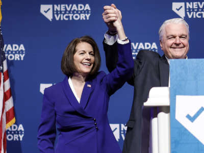 U.S. Sen. Catherine Cortez Masto and Nevada Gov. Steve Sisolak hold their hands up after giving remarks at an election night party hosted by Nevada Democratic Victory on November 8, 2022 in Las Vegas, Nevada.