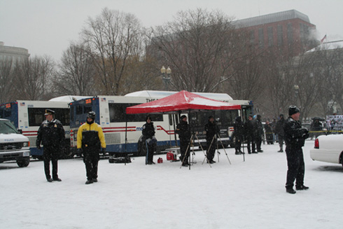 Police film the activists and arrests while simultaneously blocking the view of observers, who were forced to stand behind large busses and trucks parked in front of Lafayette Park.