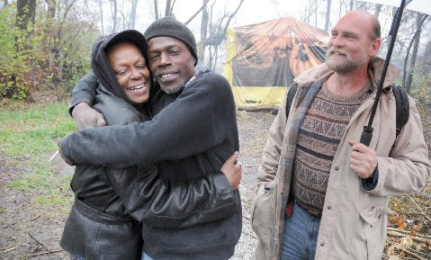Homeless advocate Madge Johnson, left, gets a welcoming hug from a homeless man living in Tent City in Nashville as Wendell Segroves, right, looks on. Photo: John Mottern
