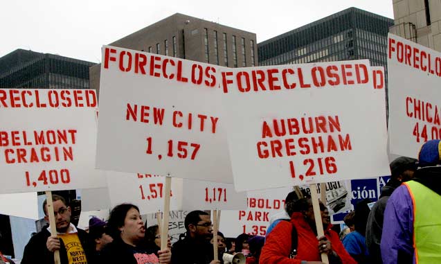 Protesters carry signs listing Chicago neighborhoods and the numbers of recent foreclosures in an October 2009 demonstration.